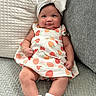 baby, bow, child, chubby_cheeks, couch, cozy, cute, dress, fruit_pattern, happy, headband, indoors, infant, pillow, portrait, relaxing, seated, smile, texture, white_socks