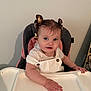 toddler, child, baby, high_chair, smile, hair_bows, face, hand, clothing, white_shirt, indoor, person, seat, table, curly_hair, cute, young_child, blue_eyes, button, skin