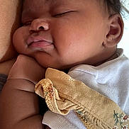 Aminah is registered to the contest to win money with this photo: arm, baby, child, close_up, comfort, cozy, cute, face, infant, newborn, peace, peaceful, portrait, resting, skin, sleeping, soft_texture, warm, white_clothing, young