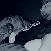 Duke joined the competition — help win amazing prizes! animal, beard, bond, cap, casual, closeup, comfort, dark_background, dog, friendship, home, indoor, laying_down, man, monochrome, pet, portrait, relaxation, resting, shirt