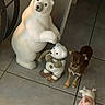 dog, chihuahua, small_dog, toy_bear, bear_statue, stuffed_animal, animal, pet, standing, portrait, indoor, tile_floor, floor, furniture, home, decor, pink_toy, brown_dog, white_bear, figurine