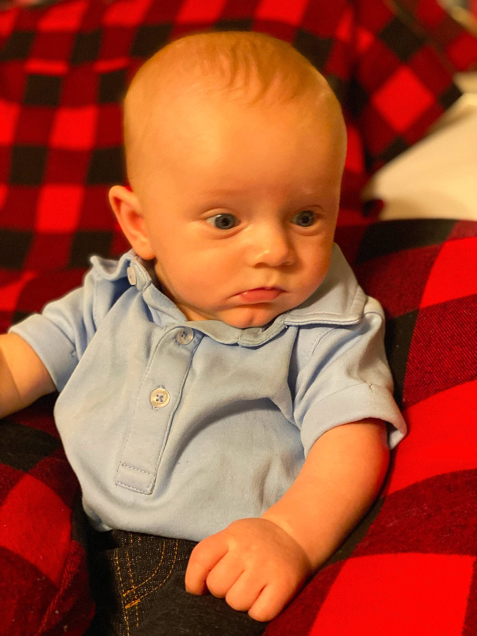 Drake is registered to the contest to win money with this photo: baby, cheek, child, chin, design, face, head, nose, pattern, person, plaid, sitting, skin, tartan, textile, toddler