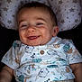 baby, smiling, cute, pillow, stars, pattern, shirt, animal_print, clothing, beige_pants, infant, happy, face, portrait, child, sitting, indoors, closeup, person, young