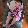 baby, infant, smiling, plush_toy, octopus_toy, pacifier, baby_rocker, gray_fabric, wooden_floor, happy, cute, child, sitting, indoors, young, human, toy, legs, feet, face