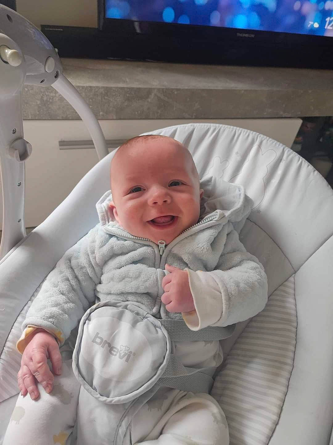 Marley a rejoint le concours — aidez-le/la à gagner de superbes lots ! baby, baby_toddler_clothing, blue, cable_television, chair, cheek, child, comfort, couch, finger, happy, iris, mouth, person, product, sitting, skin, smile, television, toddler