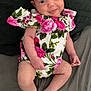 Ambre a rejoint le concours — aidez-le/la à gagner de superbes lots ! baby, infant, smiling, floral_clothing, onesie, barefoot, sitting, cute, child, portrait, skin, head, arms, legs, fingers, toes, lying_down, fabric, background, happy