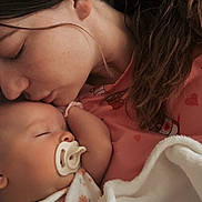 Emilia is registered to the contest to win money with this photo: baby, woman, pacifier, sleeping, blanket, kiss, love, tenderness, closeup, face, skin, hair, clothing, pink, floral, infant, mother, affection, rest, comfort