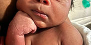 Daylen is registered to the contest to win money with this photo: arm, baby, chest, close_up, curious, cute, expression, face, hand, human, indoors, infant, newborn, person, portrait, resting, skin, soft_light, texture, young