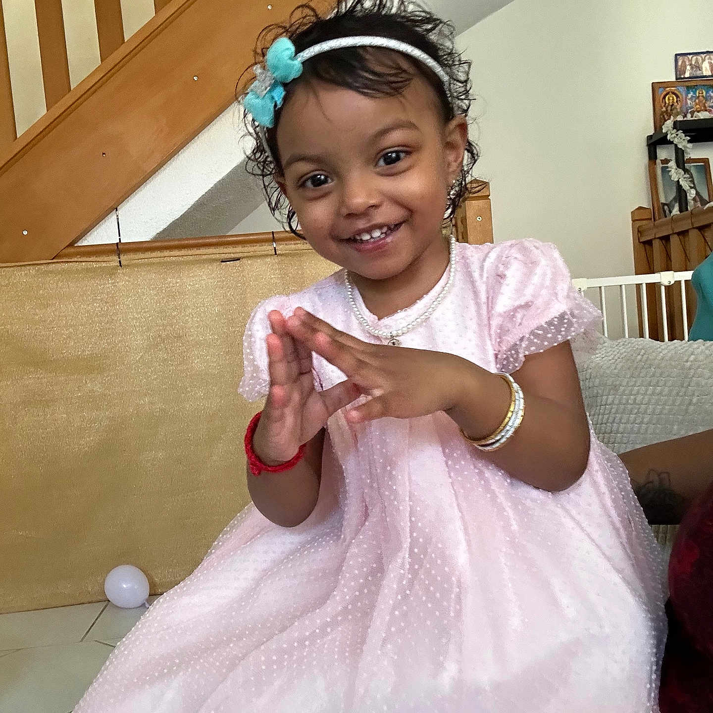 Louisa participe au concours pour gagner de l'argent avec cette photo : bracelets, child, cute, floor, girl, happy, headband, home, indoor, jewelry, pearl_necklace, person, pink_dress, playful, portrait, smiling, stairs, tile, toddler, wooden
