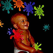 Zamir Bovillion joined the competition — help win amazing prizes! art, baby, black_background, body_paint, bright, child, colorful, diaper, face, hands, happy, infant, joyful, letters, paint, paper_cutouts, playful, sitting, smile, splat