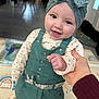 Elyna a rejoint le concours — aidez-le/la à gagner de superbes lots ! baby, child, smile, headband, green_dress, hand, indoor, play_mat, patterned_clothes, cute, person, infant, happy, holding_hand, floor, furniture, portrait, closeup, toddler, headwear