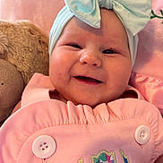 Koda joined the competition — help win amazing prizes! baby, smiling, headband, bow, pink_outfit, buttons, teddy_bear, soft_toy, closeup, face, infant, cute, happy, child, portrait, indoors, cozy, baby_clothing, baby_accessory, baby_bow