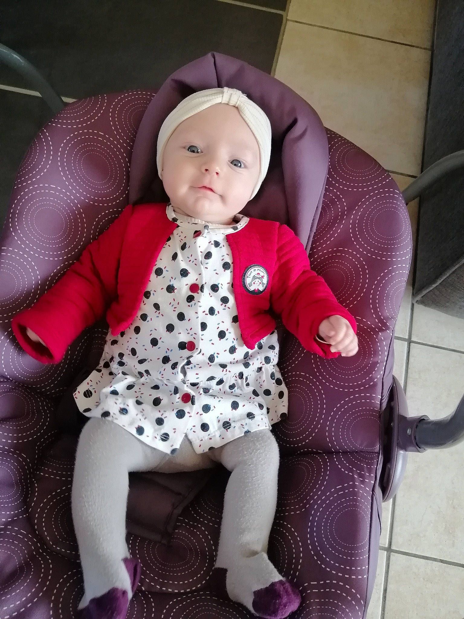 Celestine a rejoint le concours — aidez-le/la à gagner de superbes lots ! arm, baby, baby_products, baby_toddler_clothing, chair, child, comfort, doll, eye, headwear, human_body, lap, pattern, person, pink, product, purple, sitting, sleeve, t_shirt