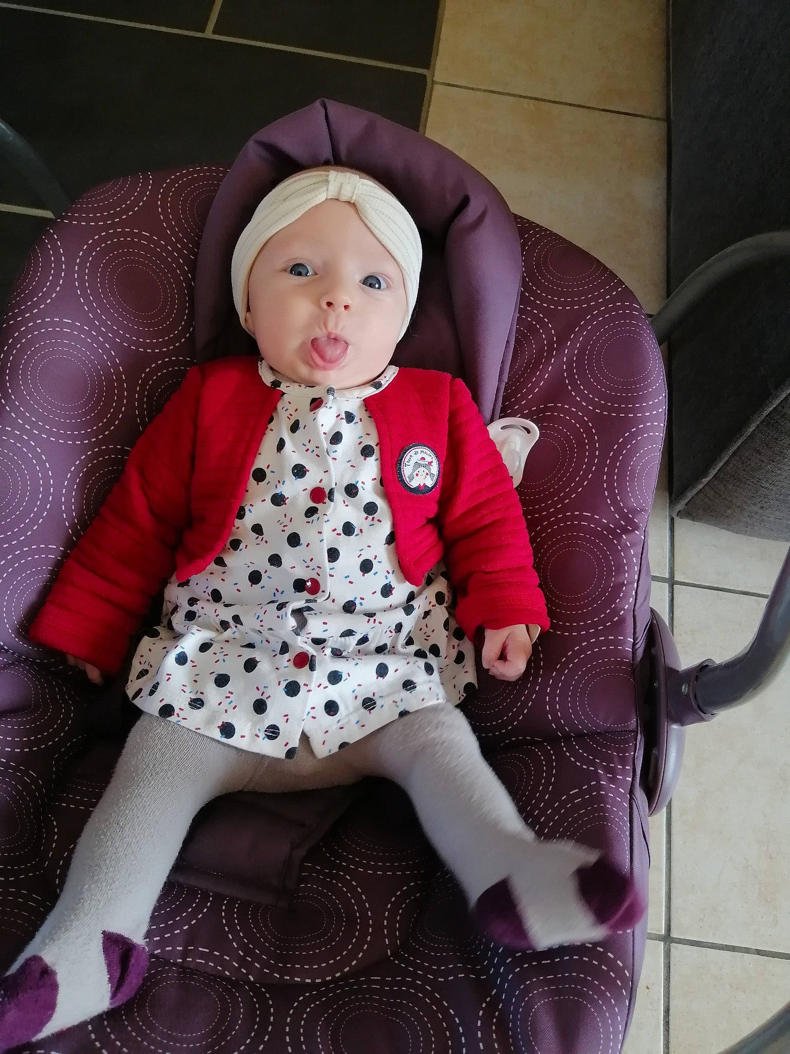 Celestine a rejoint le concours — aidez-le/la à gagner de superbes lots ! baby, baby_products, baby_toddler_clothing, cap, chair, child, costume, doll, fashion_accessory, headwear, linens, magenta, outerwear, pattern, person, pink, product, purple, sitting, sleeve