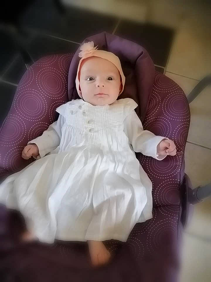 Celestine participe au concours pour gagner de l'argent avec cette photo : arm, baby, baby_toddler_clothing, bridal_accessory, bridal_clothing, day_dress, dress, embellishment, flash_photography, formal_wear, happy, headgear, headpiece, headwear, human_body, iris, lip, one_piece_garment, person, sleeve