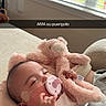 baby, pacifier, stuffed_animal, pink, blanket, oxygen_tube, sleeping, indoors, window, couch, child, cute, resting, soft_toy, cozy, infant, person, comfort, healthcare, nursery