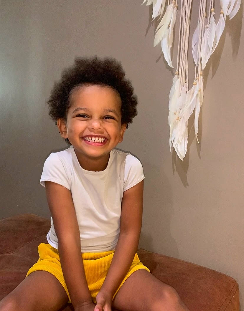 Yasmine a rejoint le concours — aidez-le/la à gagner de superbes lots ! barefoot, elbow, face, flash_photography, happy, head, human_body, human_leg, joy, knee, neck, person, shorts, shoulder, sitting, sleeve, smile, t_shirt, thigh, toddler