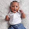 baby, child, curly_hair, white_polo, blue_shorts, fluffy_rug, smiling, happy, cute, portrait, indoor, infant, person, clothing, baby_boy, expression, skin, head, face, hands