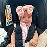 baby, infant, child, car_seat, pink_bow, headband, blanket, smile, cute, clothing, safety_harness, black, knitted, seat, indoor, portrait, person, happy, young, expression