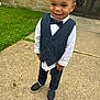 Kynd joined the competition — help win amazing prizes! child, boy, smiling, vest, bow_tie, white_shirt, pants, shoes, outdoor, sidewalk, grass, stone_wall, portrait, happy, cute, formal_wear, person, standing, daylight, fashion