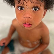 Kynd joined the competition — help win amazing prizes! child, toddler, bath, water, bubbles, curly_hair, face, eyes, skin, mouth, nose, expression, sitting, indoors, closeup, portrait, wet, innocence, baby, person