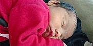 Sofia is registered to the contest to win money with this photo: baby, sleeping, red_clothing, face, resting, infant, peaceful, closeup, couch, soft_texture, indoors, skin, head, child, calm, person, cozy, portrait, young, nap
