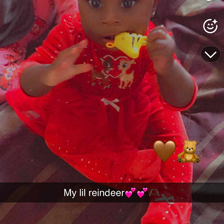 A-Vilea joined the competition — help win amazing prizes! baby, child, red_clothing, headband, toy, bed, blanket, sitting, indoors, person, face, cute, festive, music_overlay, social_media, screenshot, text_overlay, hand, eyes, expression