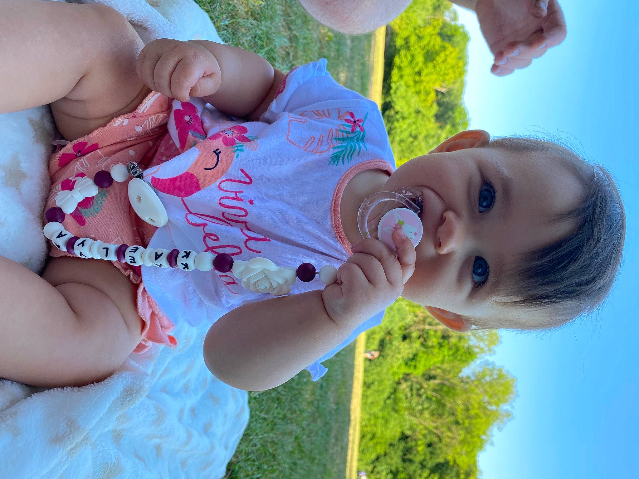 Kaëlya a rejoint le concours — aidez-le/la à gagner de superbes lots ! arm, finger, fun, grass, green, happy, leisure, light, people_in_nature, person, photograph, pink, plant, skin, sky, smile, summer, sunlight, toddler, water