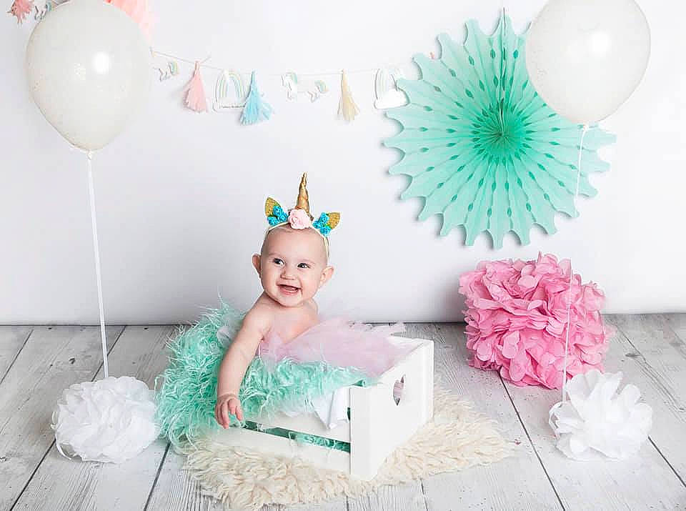 Calie a rejoint le concours — aidez-le/la à gagner de superbes lots ! baby, baby_toddler_clothing, ballet_tutu, child, costume, costume_accessory, fashion_accessory, feather, hair_accessory, headpiece, party, party_hat, person, pink, pom_pom, room, toddler, turquoise