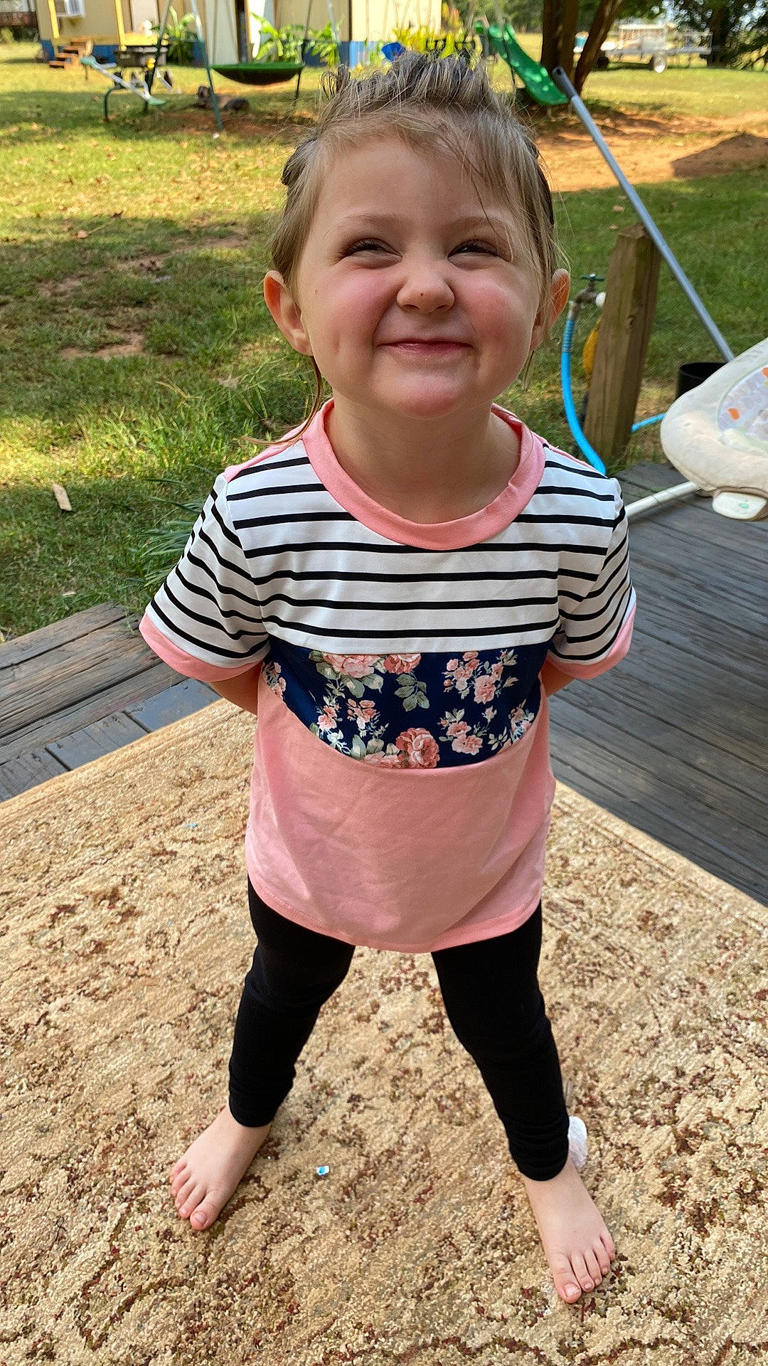 Harper is registered to the contest to win money with this photo: active_pants, baby_toddler_clothing, child, face, fun, grass, hairstyle, happy, head, joy, leggings, leisure, pattern, person, plant, recreation, sleeve, smile, t_shirt, thigh