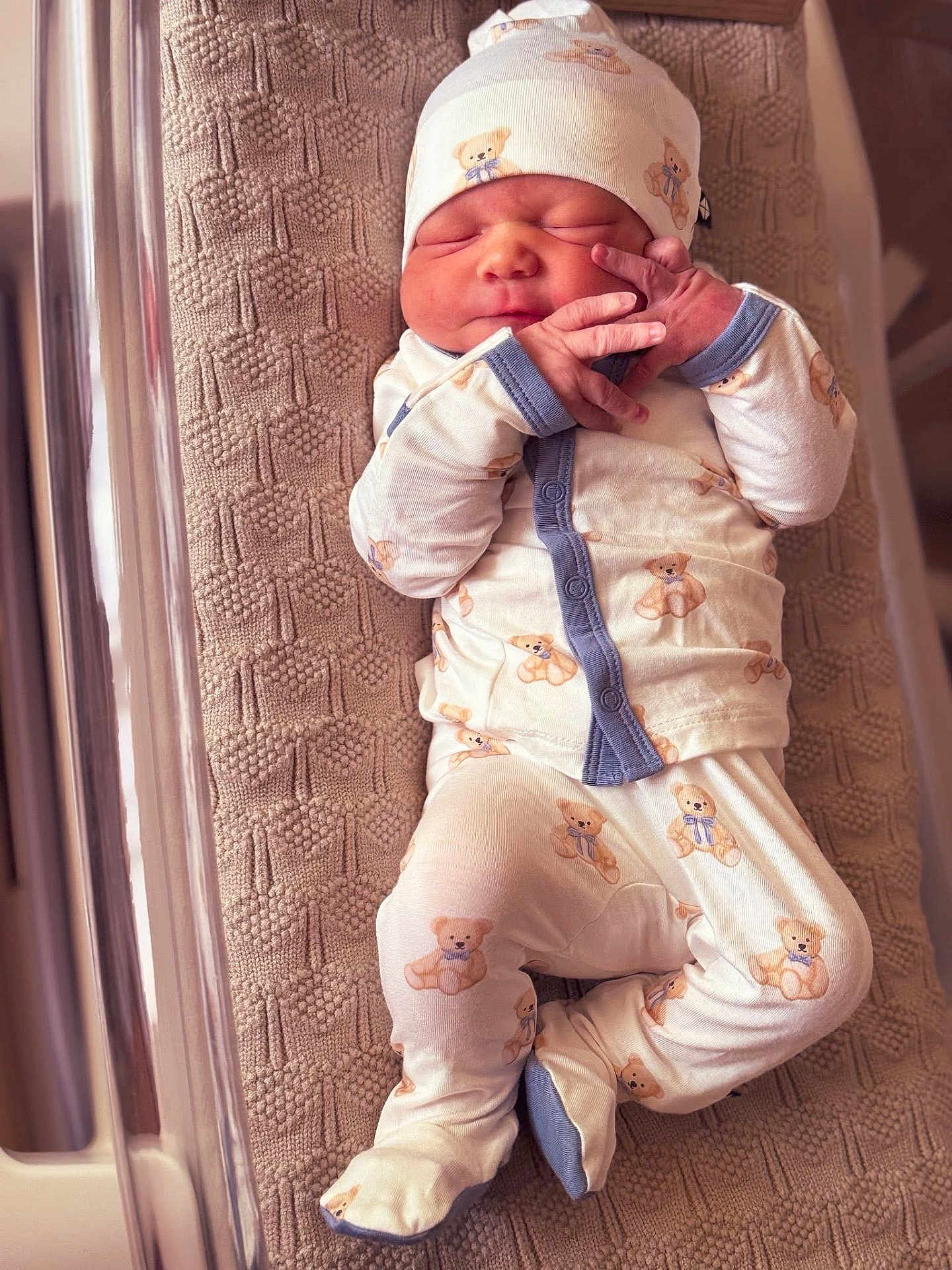 Archer is registered to the contest to win money with this photo: newborn, baby, infant, sleeping, pajamas, hat, teddy_bear_pattern, blanket, hospital_bassinet, cute, peaceful, small_hands, footed_pajamas, soft_lighting, indoors, person, sleep, resting, child, newborn_clothing