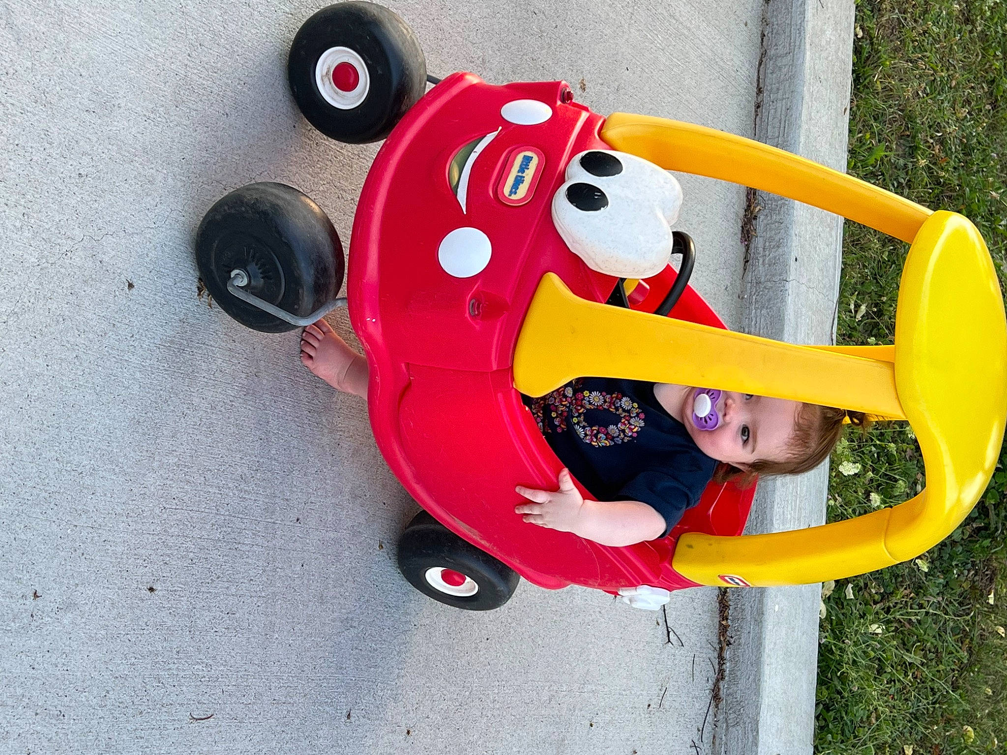Maislynn is registered to the contest to win money with this photo: auto_part, automotive_wheel_system, baby_toys, carmine, circle, fun, gas, hat, magenta, motor_vehicle, person, plastic, recreation, steering_wheel, toddler, toy