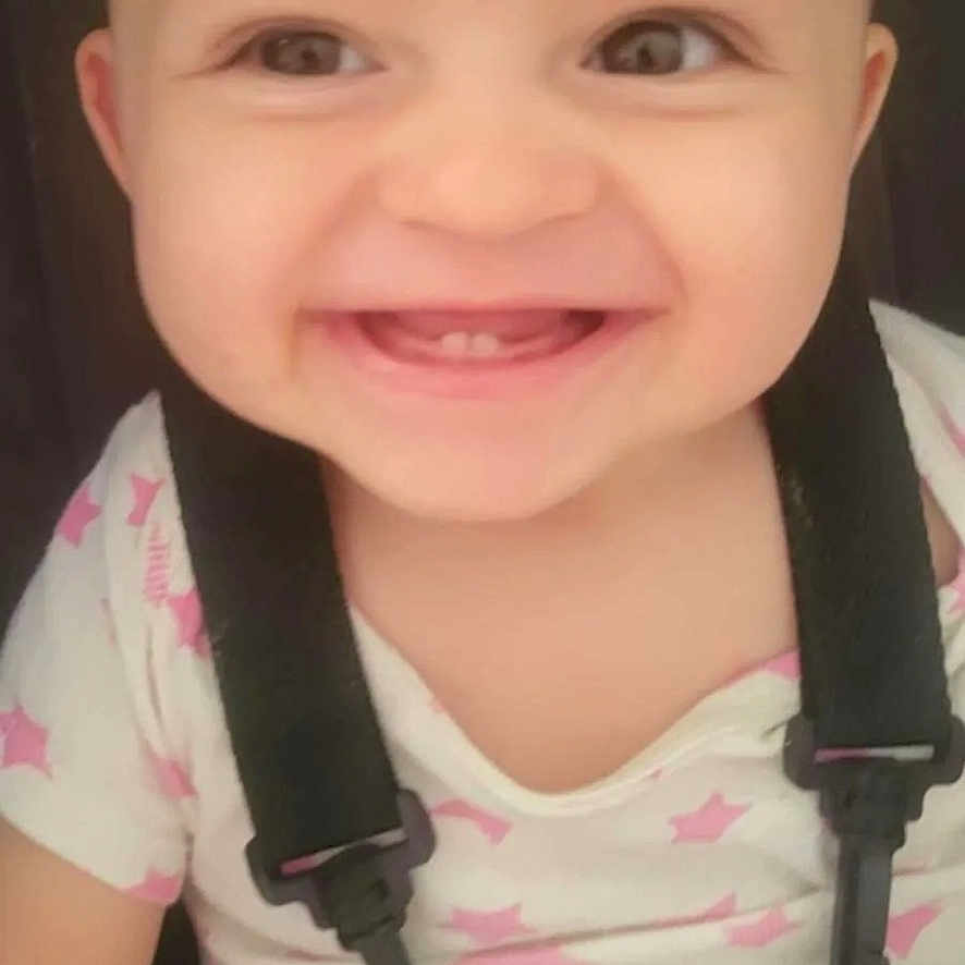 Zèlima participe au concours pour gagner de l'argent avec cette photo : baby, baby_clothing, baby_face, baby_girl, baby_smile, child, childhood, closeup, cute, face, happy, harness, indoors, infant, pink_stars, portrait, smiling, teeth, white_shirt, young_child