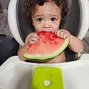 Jaxon joined the competition — help win amazing prizes! toddler, child, watermelon, high_chair, food, snack, curly_hair, eating, face, hands, indoor, table, plate, green, red, fruit, summer, cute, messy, portrait