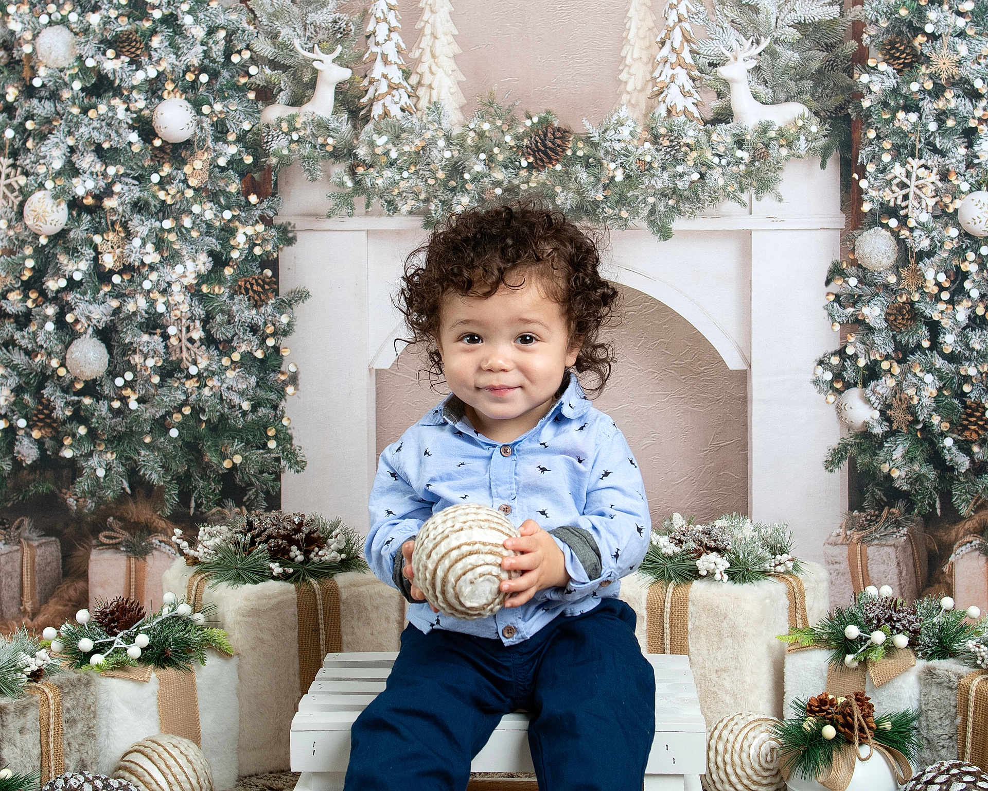 Jaxon joined the competition — help win amazing prizes! toddler, child, curly_hair, blue_shirt, navy_pants, holiday_decor, christmas, ornament, pine_branches, wrapped_gifts, white_bench, festive, smile, indoor, seasonal, decorations, reindeer, winter, cute, portrait