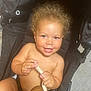 toddler, child, curly_hair, smile, stroller, plush_toy, bare_chest, hands, happy, indoor, person, infant, cute, baby, seat, toy, skin, face, expression, childhood
