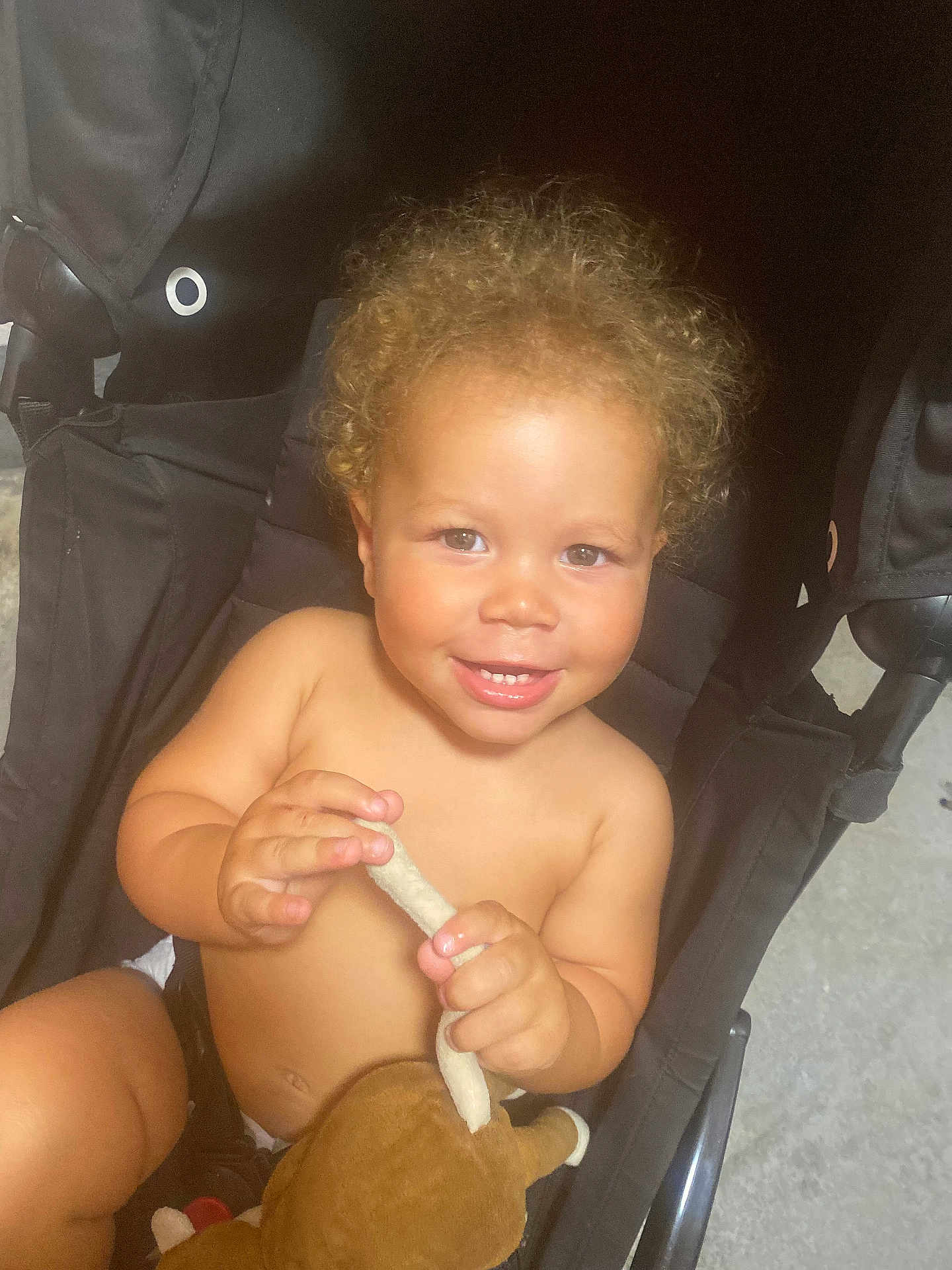 Deavon participe au concours pour gagner de l'argent avec cette photo : toddler, child, curly_hair, smile, stroller, plush_toy, bare_chest, hands, happy, indoor, person, infant, cute, baby, seat, toy, skin, face, expression, childhood
