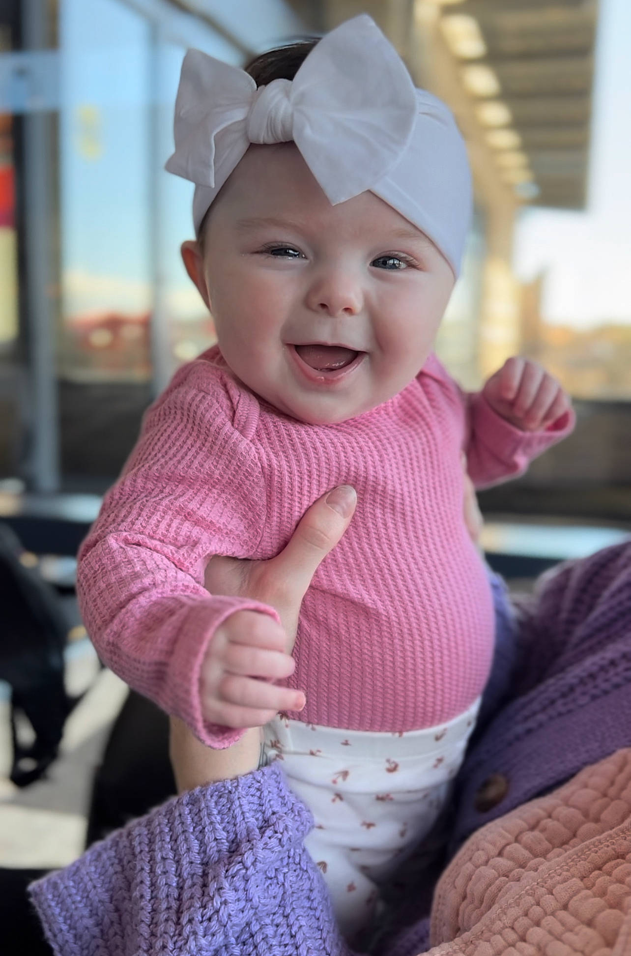 Lennon is registered to the contest to win money with this photo: baby, baby_toddler_clothing, cap, child, eye, face, fun, gesture, happy, head, headgear, headwear, human_body, joy, magenta, person, pink, purple, skin, sleeve