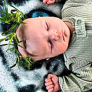 Curtis joined the competition — help win amazing prizes! baby, sleeping, infant, green_clothing, blanket, soft_texture, leaf_crown, peaceful, cute, portrait, closeup, resting, child, indoors, cozy, hands, head, peace, toddler, nature_elements
