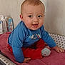 baby, background, blue_shirt, child, cushion, cute, face, footwear, happy, head, indoor, infant, person, pink_towel, red_pants, sitting, skin, smiling, star_pattern, toddler