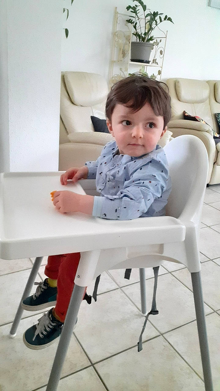 Mathis a rejoint le concours — aidez-le/la à gagner de superbes lots ! arm, baby, baby_toddler_clothing, chair, comfort, dress, floor, flooring, furniture, hair, houseplant, joint, knee, leg, person, shorts, shoulder, table, toddler, white