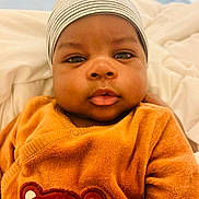 Giannis a rejoint le concours — aidez-le/la à gagner de superbes lots ! baby, beanie, bear_design, blanket, child, closeup, clothing, cute, eyes, face, hat, indoors, infant, orange, person, portrait, skin, sweater, warm, young