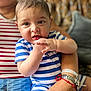 arm, baby, blue_and_white, bracelet, child, couch, curious, expression, face, hand, holding, human, indoor, person, portrait, sitting, skin, striped_clothing, upclose, watch
