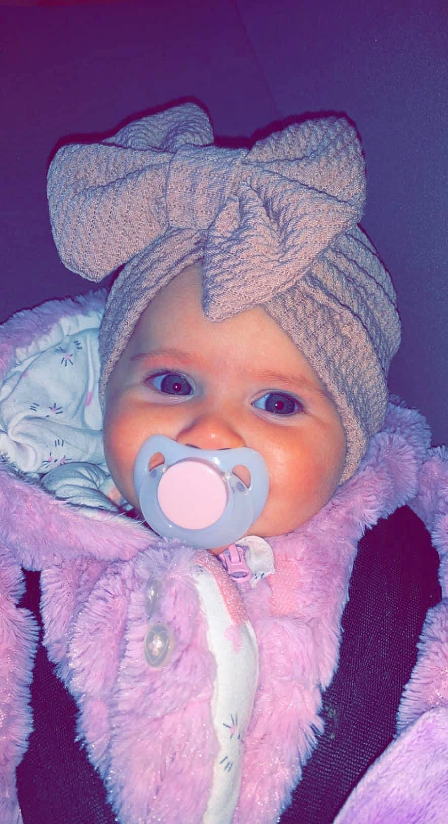 Nina participe au concours pour gagner de l'argent avec cette photo : baby, baby_toddler_clothing, cap, cheek, cool, eye, eyebrow, head, headgear, headwear, human_body, iris, lip, nose, organ, outerwear, person, pink, purple, skin