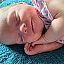 baby, sleeping, infant, hand, face, blanket, textile, skin, closeup, peaceful, cute, child, portrait, soft_light, floral_clothing, rest, newborn, adorable, comfort, relaxation