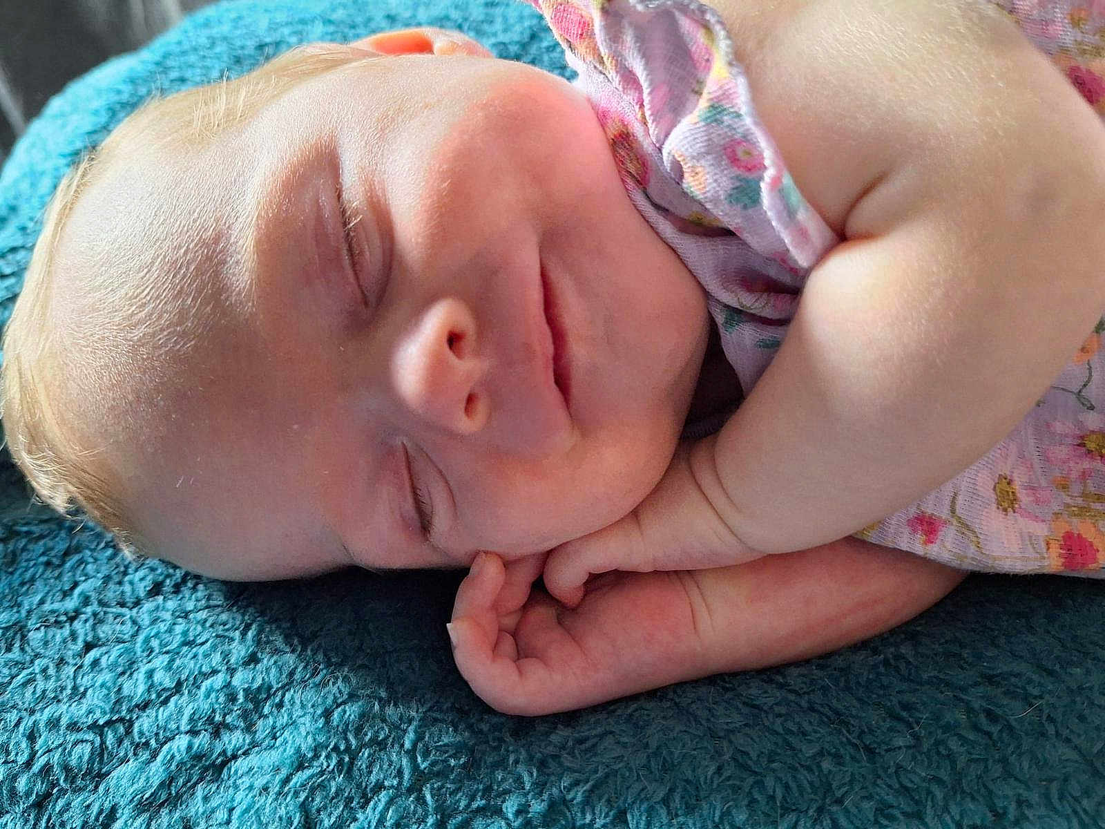 Ophelia is registered to the contest to win money with this photo: baby, sleeping, infant, hand, face, blanket, textile, skin, closeup, peaceful, cute, child, portrait, soft_light, floral_clothing, rest, newborn, adorable, comfort, relaxation