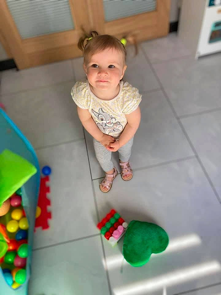 Eva participe au concours pour gagner de l'argent avec cette photo : baby, baby_playing_with_toys, baby_products, baby_toddler_clothing, baby_toys, child, floor, flooring, fun, green, hardwood, person, plastic, play, room, sitting, sock, toddler, toy, wood