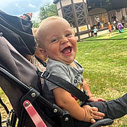 Louis joined the competition — help win amazing prizes! baby, stroller, smiling, child, outdoor, grass, people, play, crowd, building, stage, happy, seatbelt, casual_clothing, daylight, event, fun, small_child, park, nature