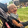 baby, stroller, smiling, child, outdoor, grass, people, play, crowd, building, stage, happy, seatbelt, casual_clothing, daylight, event, fun, small_child, park, nature