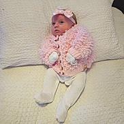 Esmae joined the competition — help win amazing prizes! baby, infant, pink_sweater, headband, knitted_clothing, white_tights, mittens, blanket, bed, cute, portrait, soft_texture, cozy, sleepwear, lying_down, newborn, indoor, child, cute_outfit, pastel_colors